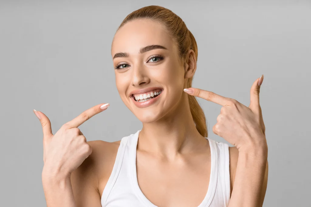 Woman pointing at bright teeth | 24th Street Dental in Phoenix, AZ