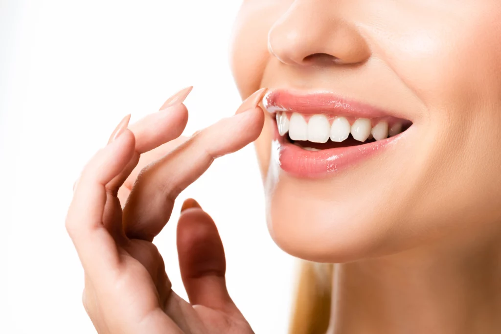 Woman smiling and pointing at teeth whitening | 24th Street Dental in Phoenix, AZ