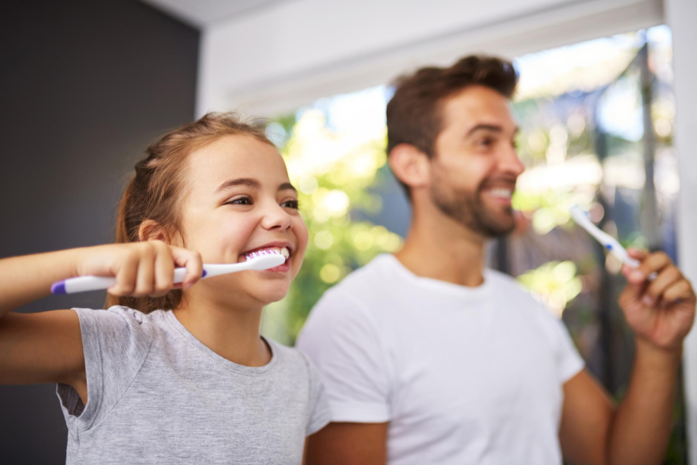 A person brushing their teeth and smiling